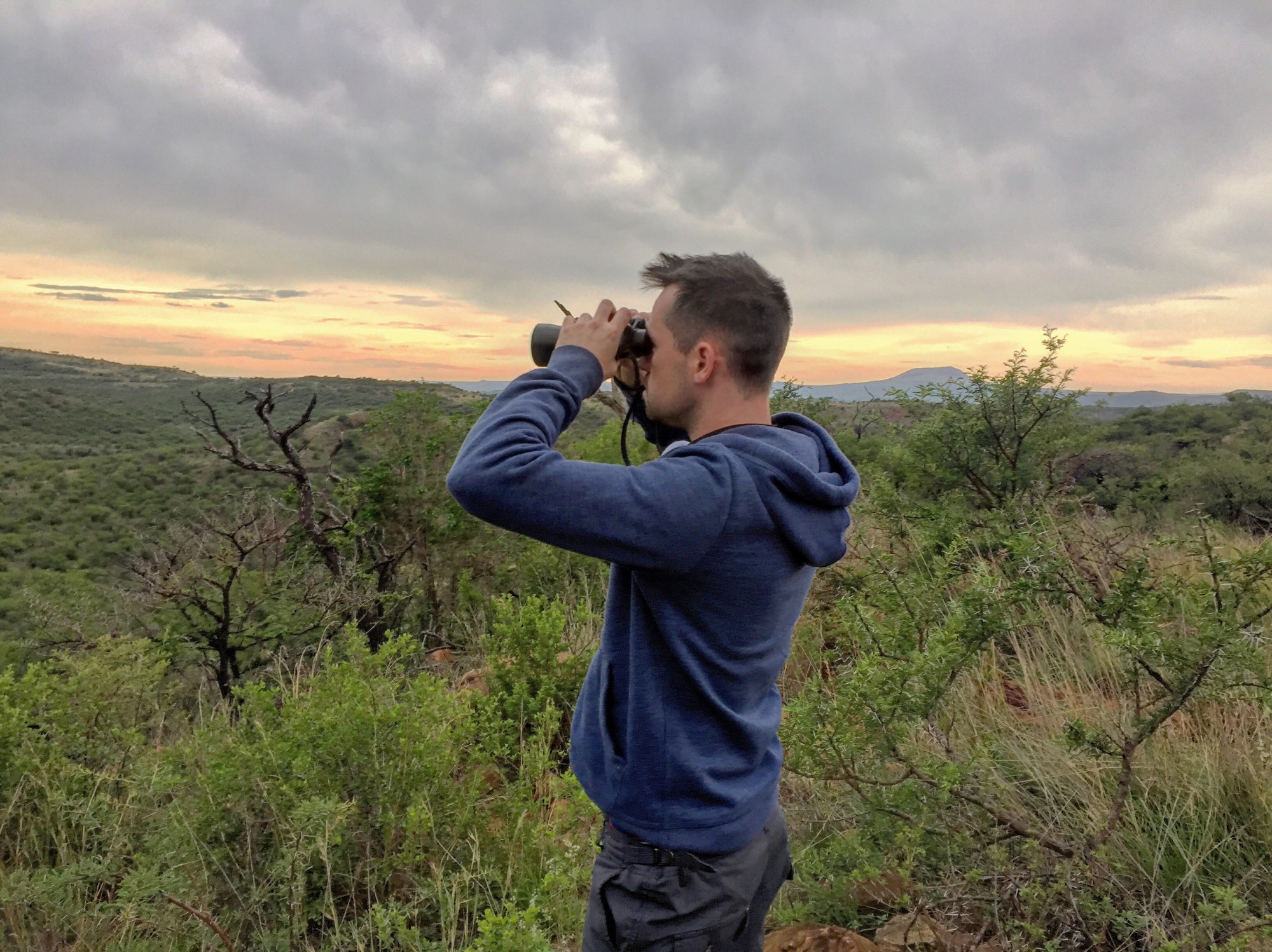 Man met verrekijker in natuur van Zuid-Afrika