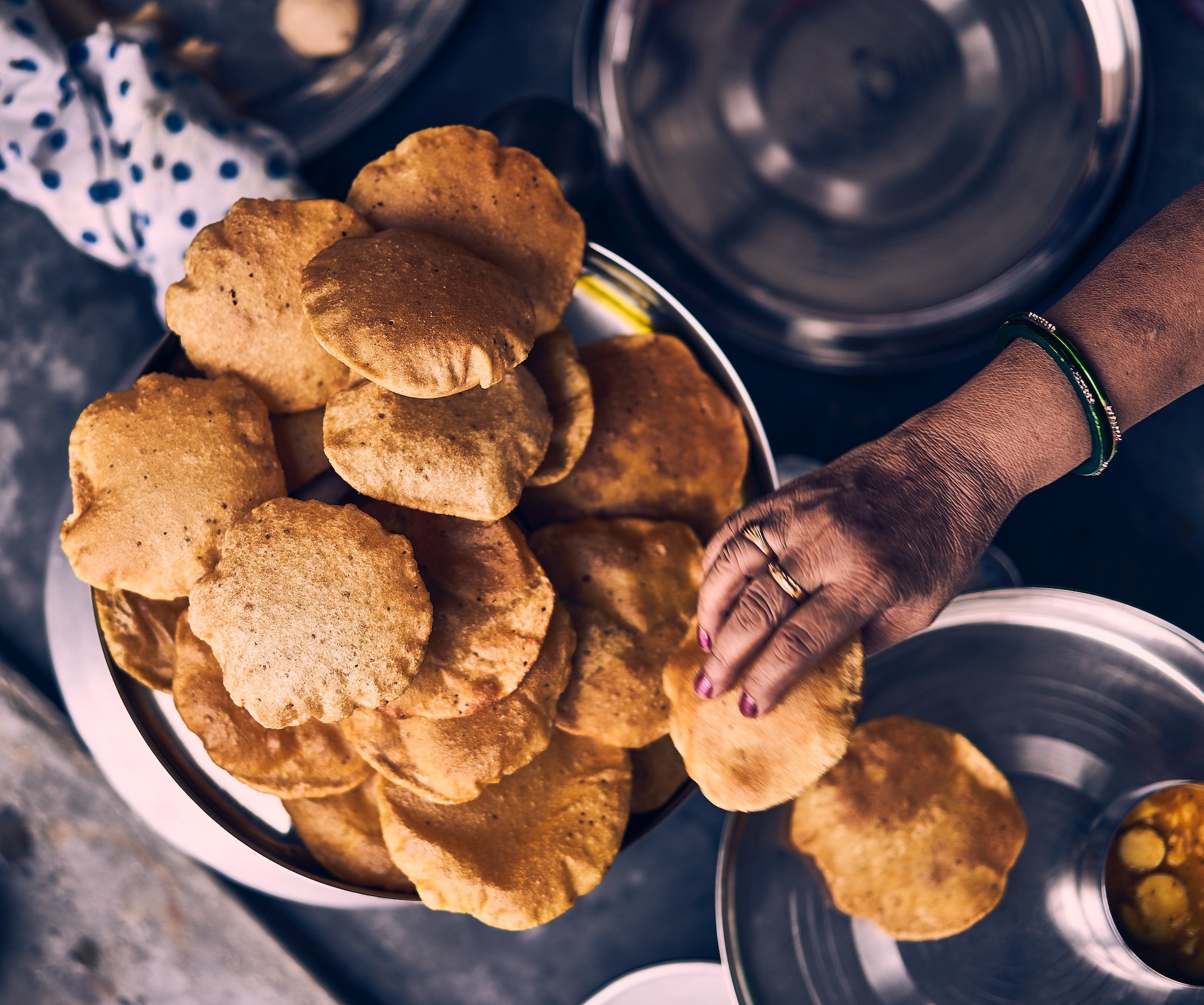 Vrouw eet Pooris met haar rechterhand in India