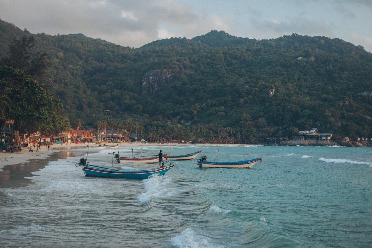 Kustlijn van Koh Phangan met boten en huisjes