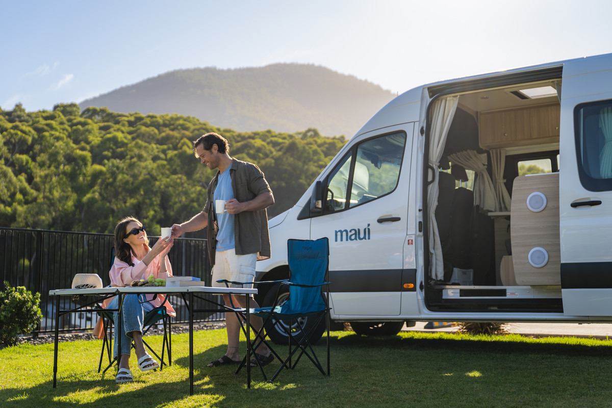 Mensen aan een tafeltje bij hun Maui Ultima camper