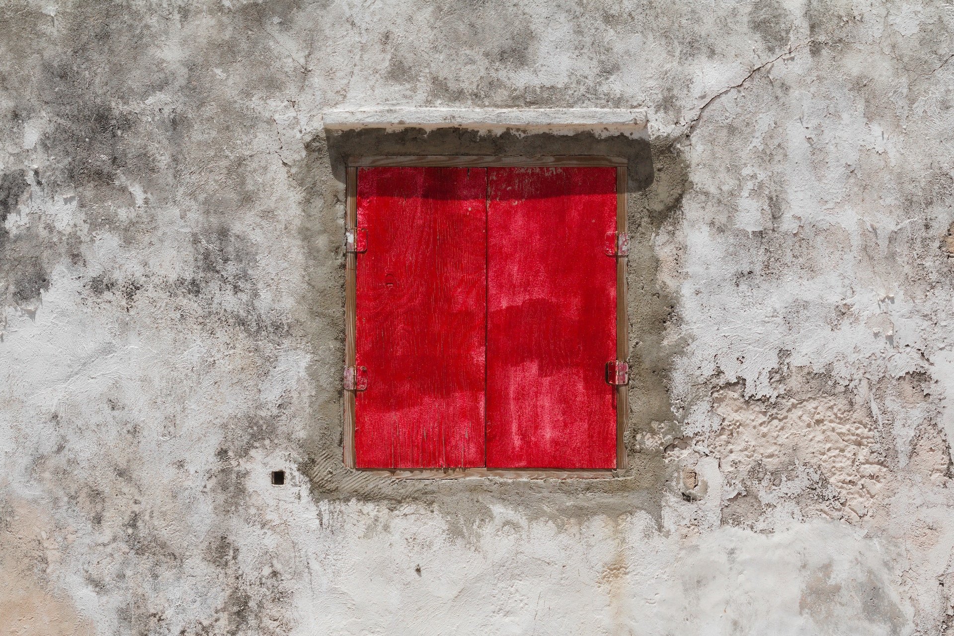 Oud raam met rode luiken in Bonaire