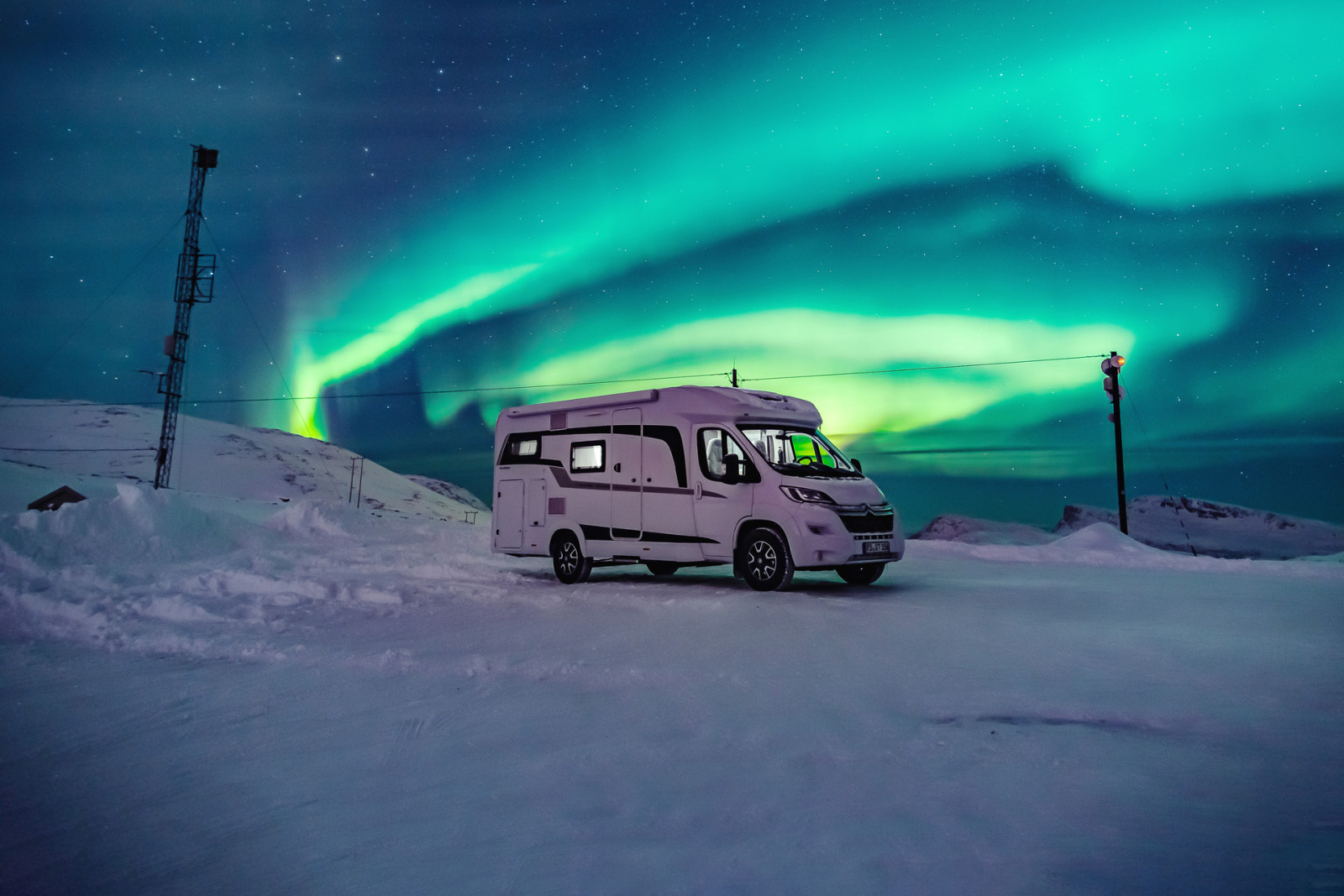 Camper in sneeuwlandschap in IJsland bij noorderlicht