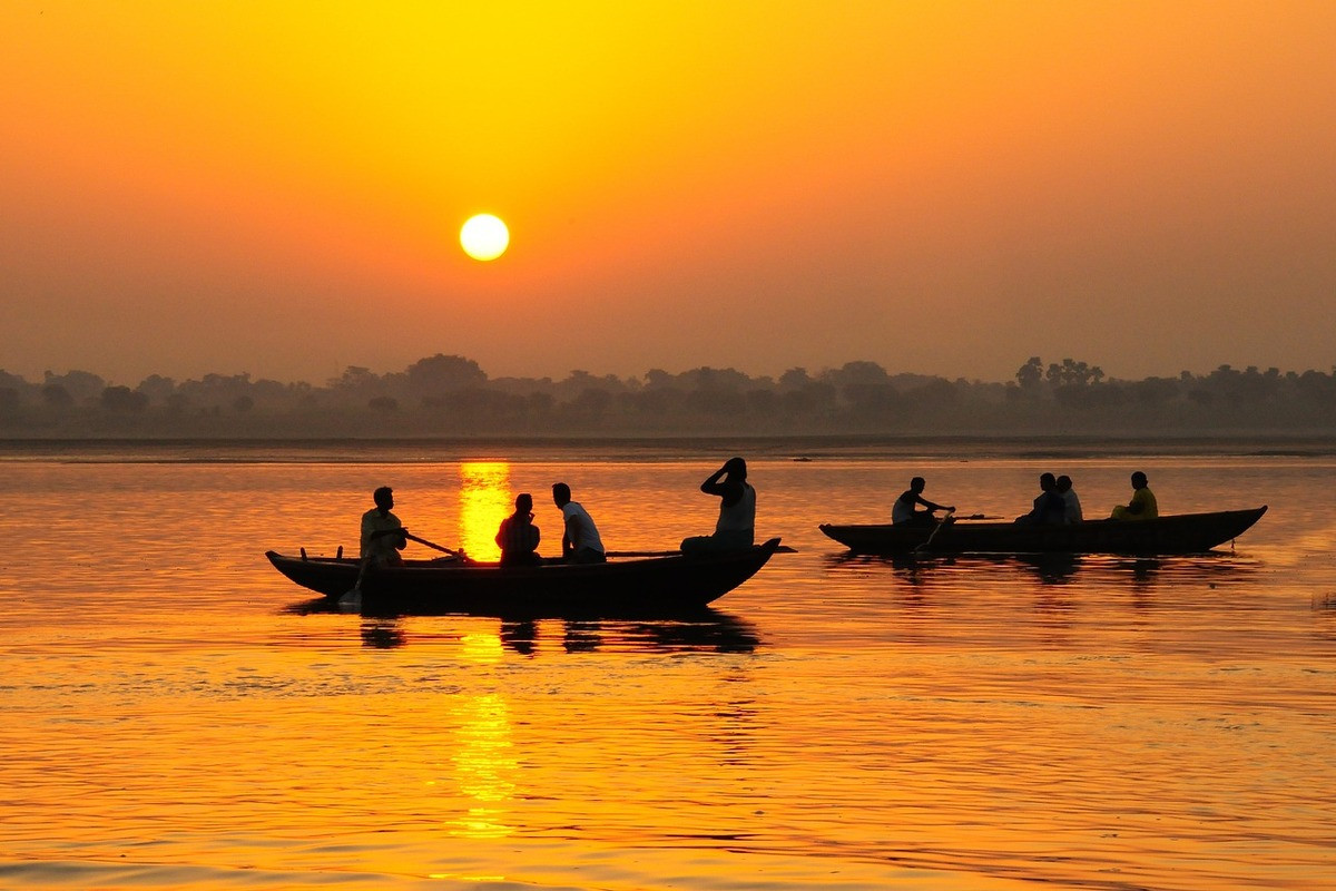 Bootjes varen bij zonsondergang bij Varanasi