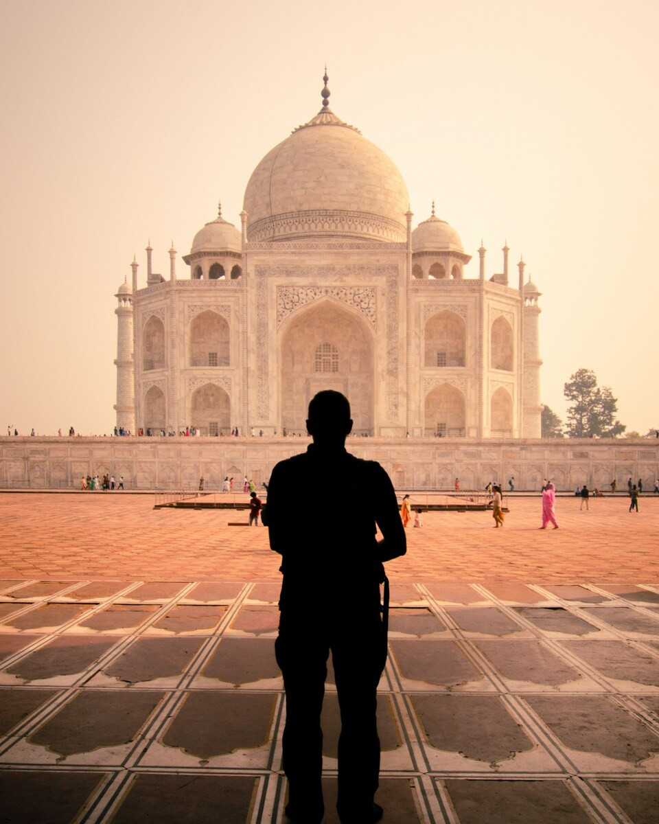 Een man staat voor de Taj Mahal
