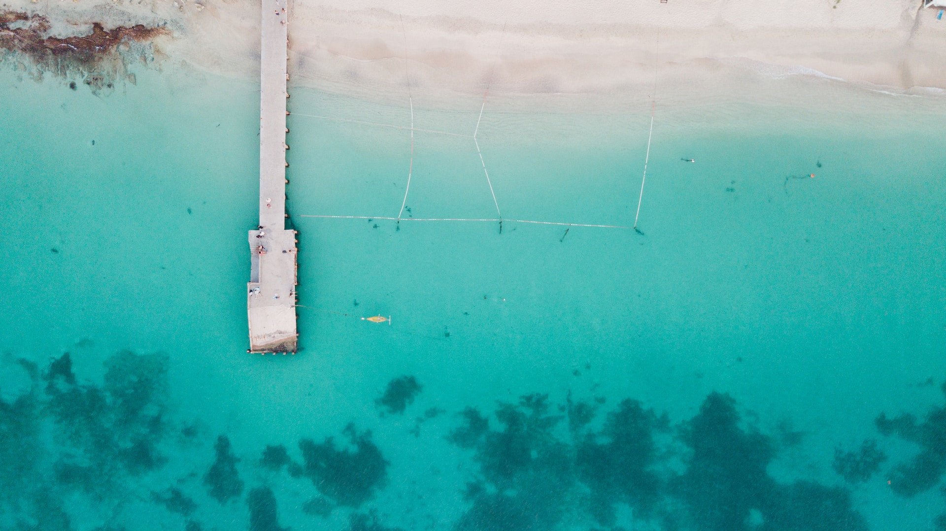 Droneshot van pier op strand