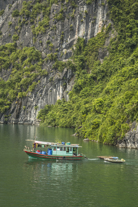 Locals varend op een schip in Halong Bay in Vietnam